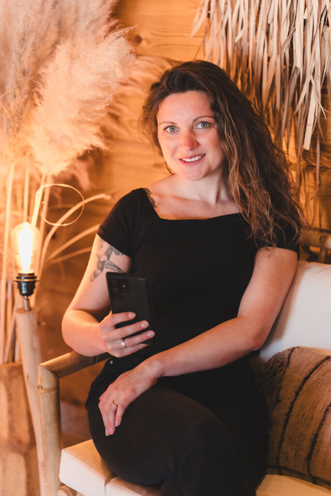 Janina sitzt auf einer Bank bei der Erstellung von Social Media Inhalten